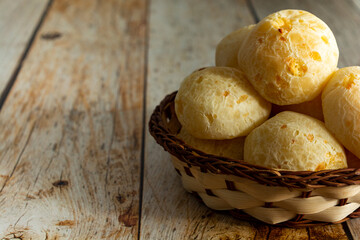brazilian cheesebread or 'pao de queijo' in a wooden basket and wooden table