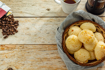 many cheese breads or 'pão de queijo' in basket and french press coffee maker and coffee beans,...