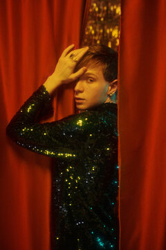Gender Neutral  Man Between Red Curtains