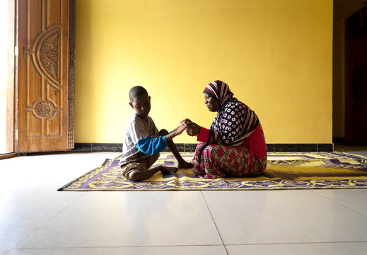 A Mother holds hands with her mentally and physically disabled son. 