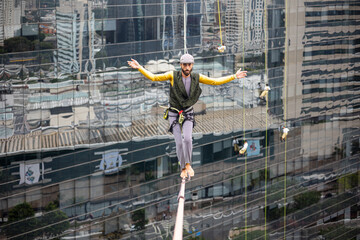 Man doing slackline between two buildings