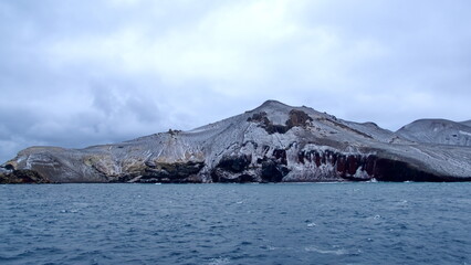 Snow dusted mountains surrounding a crater bay on Deception Island, Antarctica