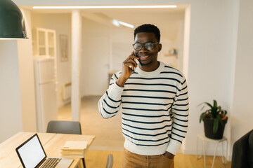 Happy young man having phone call conversation at home