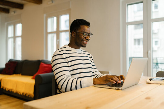 Smiling man having video call via computer indoors