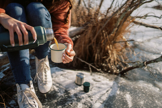 woman with ice skates pouring a hot drink