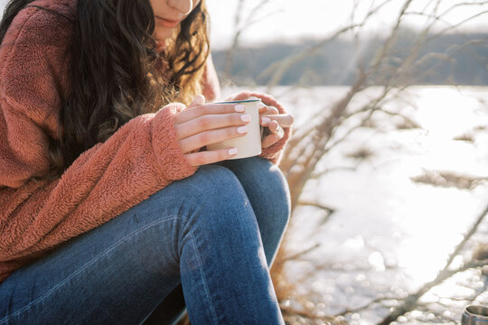 woman with ice skates holding a hot drink