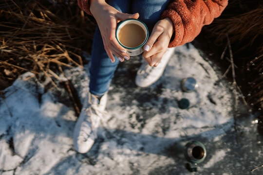 woman with ice skates pouring a hot drink