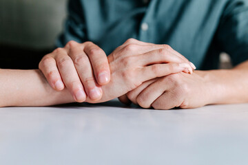 Crop couple holding hands together