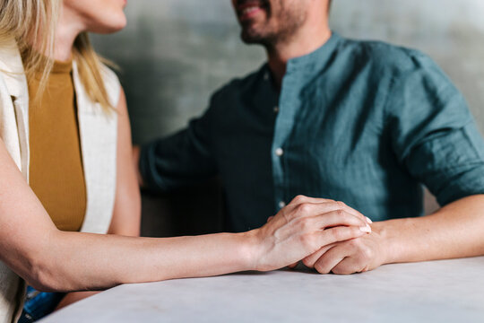 Crop couple holding hands together