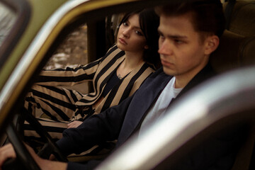 A stylish couple inside a car