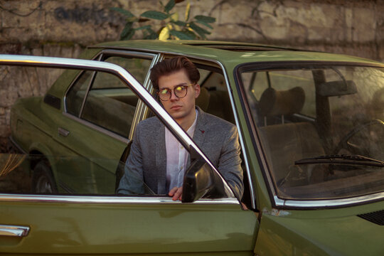 A stylish man inside a car with  sunlights
