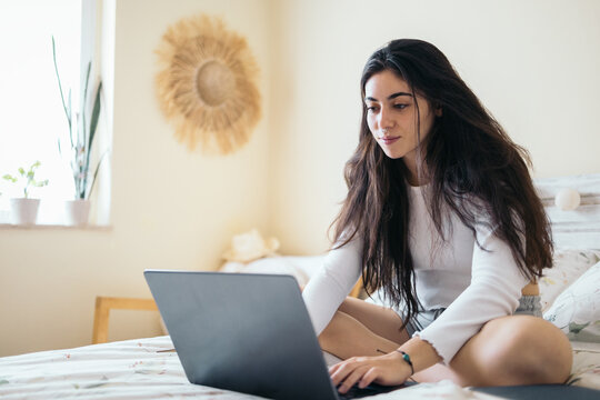 Young Woman Using Laptop In The Bedroom