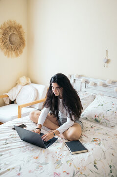 Freelancer using laptop in bed