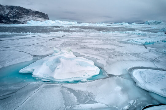 Iceberg surrounded by sea ice in wintry Arctic Ocean
