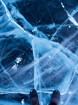 Feet & blowing snow drift atop stunning fractures of frozen ocean ice