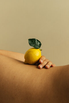 Curve of woman's waist with lemon balanced on top