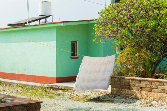 White sheet on a clothesline outside of a rural house in Mexico