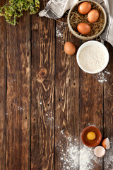 Aesthetic composition with pastry, eggs and flour on wooden background. Homemade pastry in rustic...