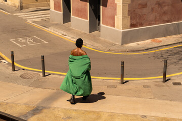 Black man walking through the town with overcoat