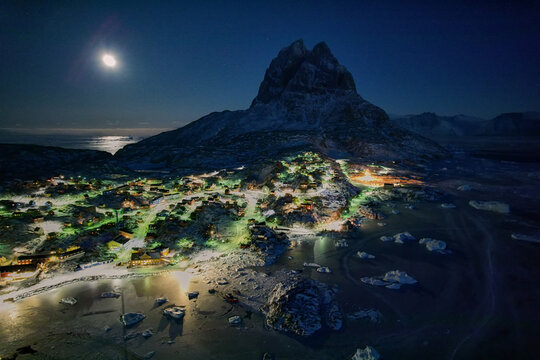 Greenlandic Arctic, Uummannaq island town lights, polar night, moon