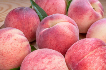 Fresh Sweet Peach on pink wooden  background, Pink and yellow Peach fruit with leaf on bamboo basket.