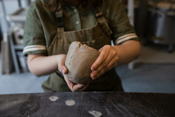 The creative process of creating a clay mug by a female ceramist