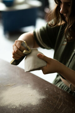 Close-up of the process of cleaning a clay mug from roughness