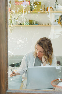 A tailor calculates fabric costs at her working place