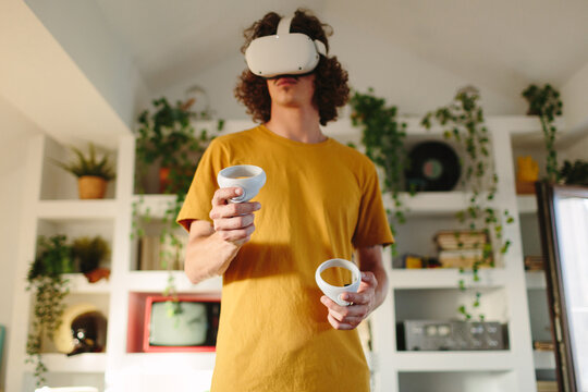 Young man with controllers and VR headset