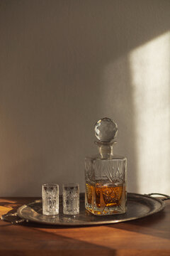 Bottle With Strong Alcohol Drink And Glasses On Sunlight. 