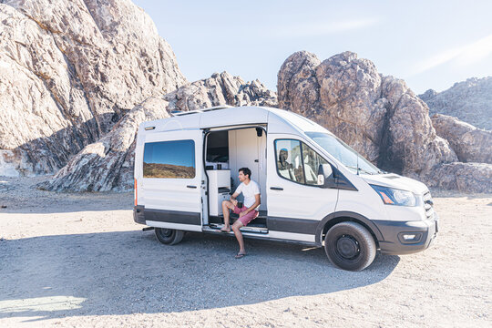 Man Drinking Coffee Sitting In A Camper Van