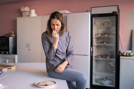 professional young woman pastry chef testing her artisan cookies in he