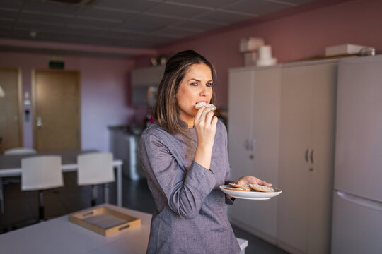 professional young woman pastry chef testing her artisan cookies in he