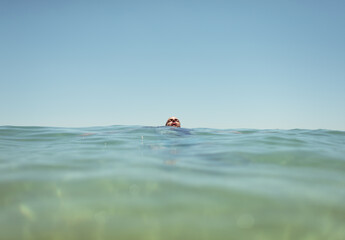 Distant man floating on the sea