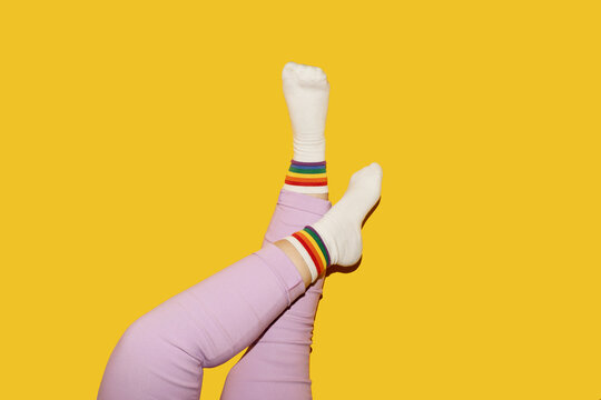 Legs in funny socks on yellow background