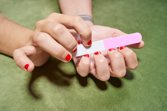 A transgender man filing his nails