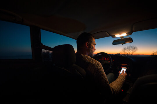 Driver inside car checking mobile phone 