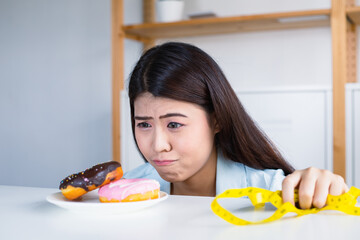 Asian women have a craving for delicious donuts. At the same time she aiming to lose weight.