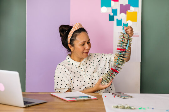 Woman holding money lei in studio