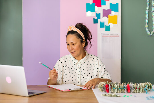 Woman zooming on laptop selling money leis