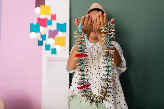Woman holding graduation money lei in studio