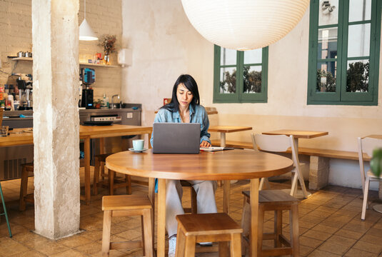 Freelance woman Working Alone In Coffee House
