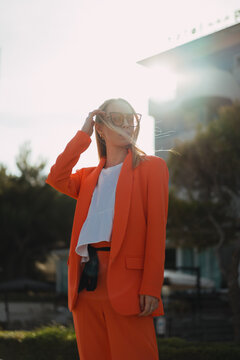 Fashionable woman in orange clothes in the city