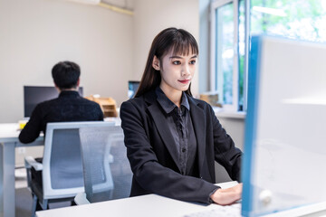 A businesswoman in an office with a black shirt and skirt