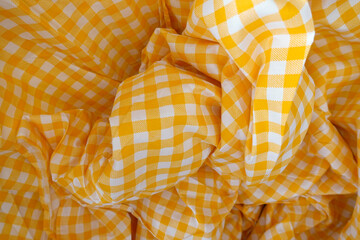 Close up of  wrinkled yellow bedding sheets .texture of yellow fabric draped cloth.
