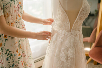 seamstress adjusting a wedding dress 
