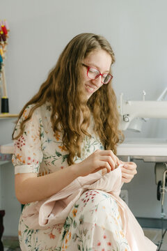 happy Young seamstress sewing