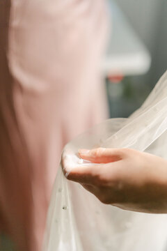 hand of seamstress touching   a veil 