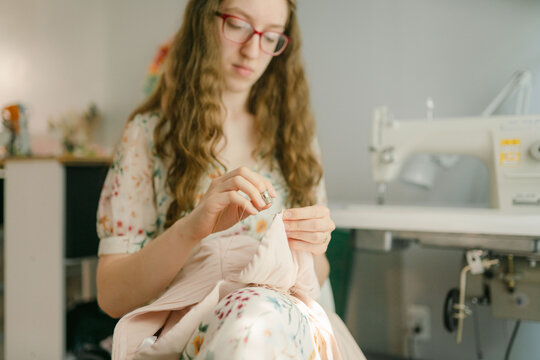 focused young woman sewing 