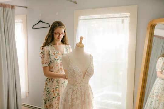 seamstress adjusting a wedding dress 